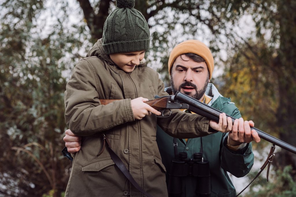 Father Showing Son How To Load Gun